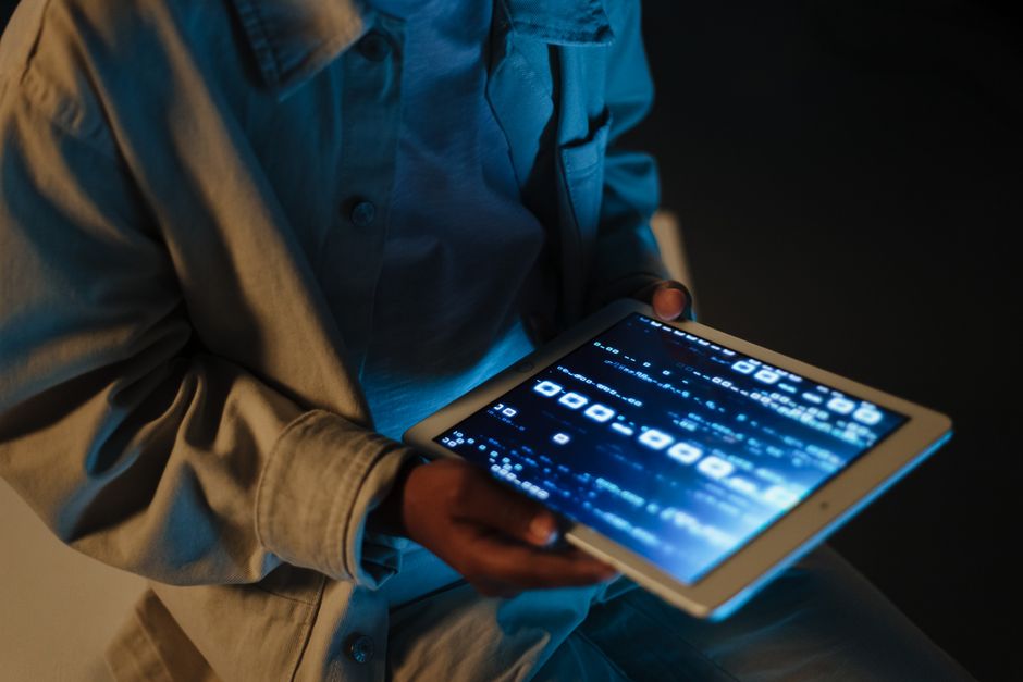 Close-up of hands holding a tablet displaying an online store with a prominent discount code, representing online deal searching.