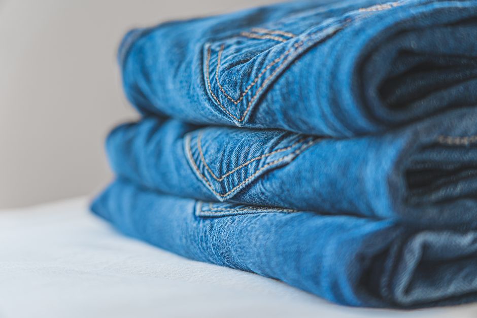 A diverse collection of women's jeans in various washes (light, medium, dark) and styles (skinny, straight, wide-leg) neatly arranged, symbolizing versatile wardrobe options.
