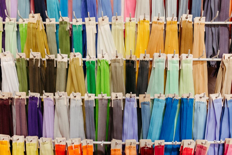 Close-up of different textured fabric swatches in neutral colors, labeled with sustainable material types.