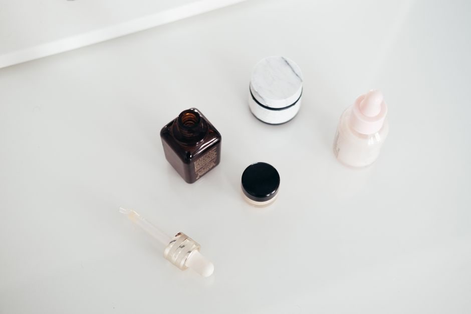 A collection of gel cleansers, fluid sunscreens, and hyaluronic acid serums neatly arranged on a bathroom counter.