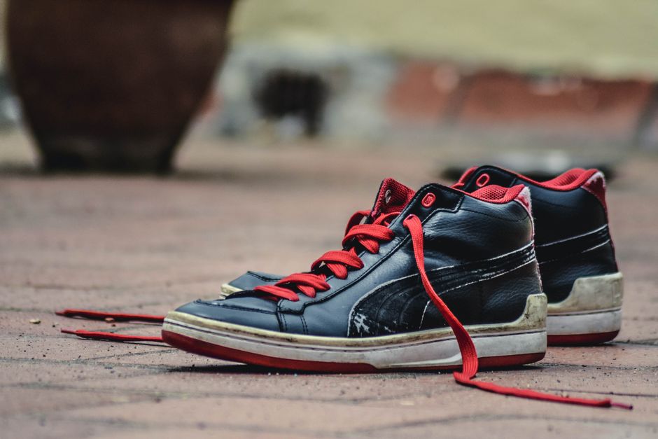 A pair of sturdy, comfortable walking shoes, slightly worn, resting on a stone pavement, ready for another journey.