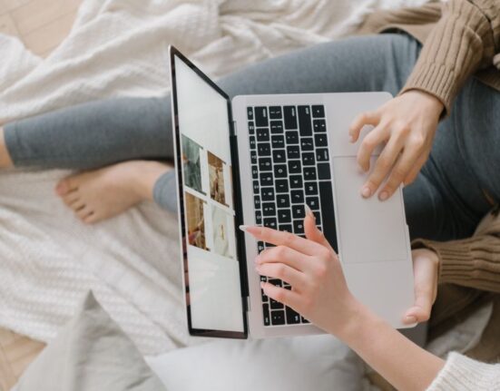 A woman comparing prices of beauty products on her laptop with multiple tabs open, symbolizing thorough research for online deals.
