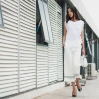 A busy woman in a chic, minimalist outfit walking confidently through a European city street, embodying comfort and style.