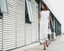 A busy woman in a chic, minimalist outfit walking confidently through a European city street, embodying comfort and style.