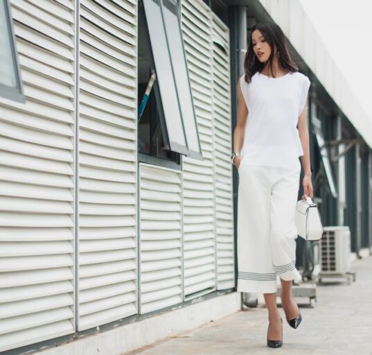 A busy woman in a chic, minimalist outfit walking confidently through a European city street, embodying comfort and style.