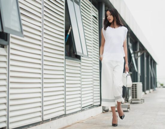 A busy woman in a chic, minimalist outfit walking confidently through a European city street, embodying comfort and style.