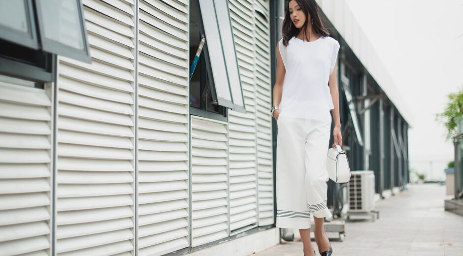 A busy woman in a chic, minimalist outfit walking confidently through a European city street, embodying comfort and style.