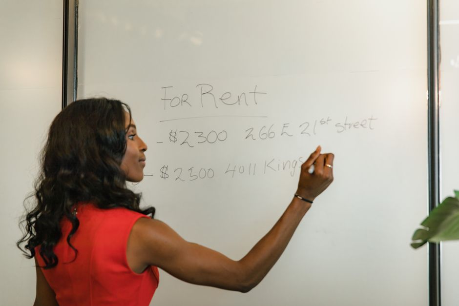 A woman at her desk intently viewing a comparison table on her computer screen, which lists different prices and features for products from various retailers, aiding in her search for the best smart online deals and offers.