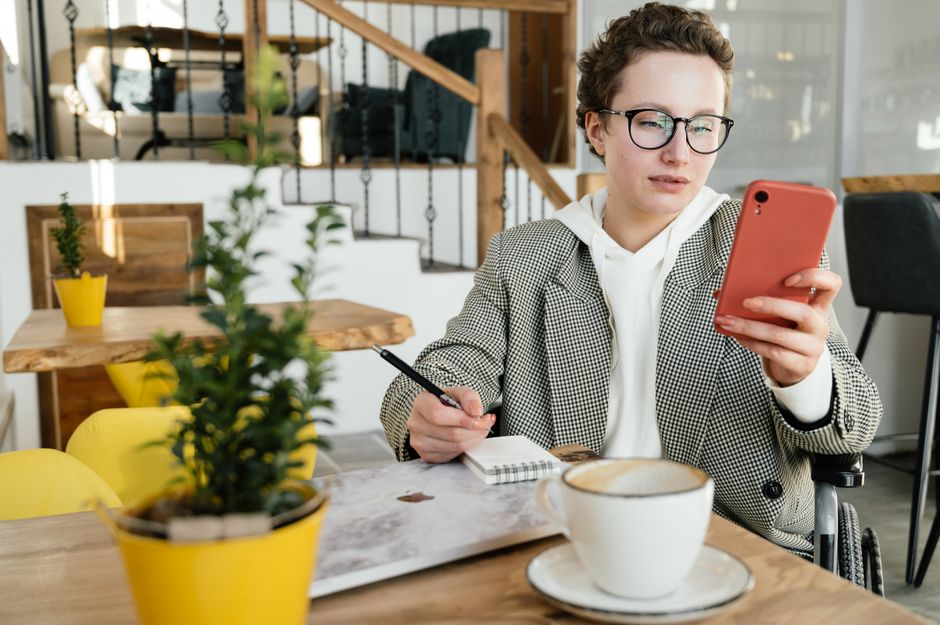 A woman in a modern setting, holding a smartphone, actively comparing product prices and deals on different e-commerce apps or websites.