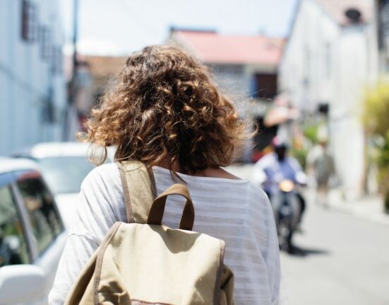 A woman confidently navigating a busy European city street with a stylish anti-theft backpack, illustrating comfortable and secure urban travel.