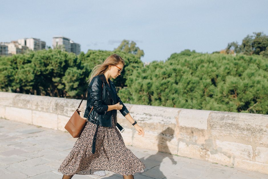 A woman confidently walking through a bustling city square, wearing a stylish yet practical crossbody bag that appears to hold her daily essentials close and secure.