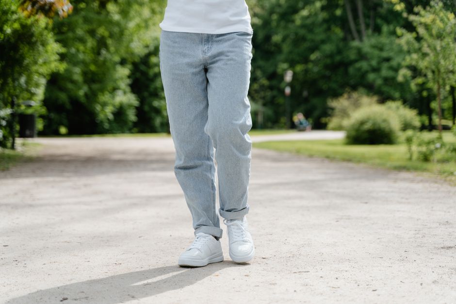 A stylish woman in dark wash straight-leg jeans and a tucked-in blouse walking confidently on a city street, showcasing a perfect fit for work or travel.