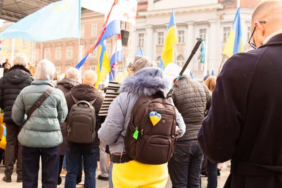 Woman wearing a modern anti-theft backpack confidently navigating a busy cobblestone street in a European city.
